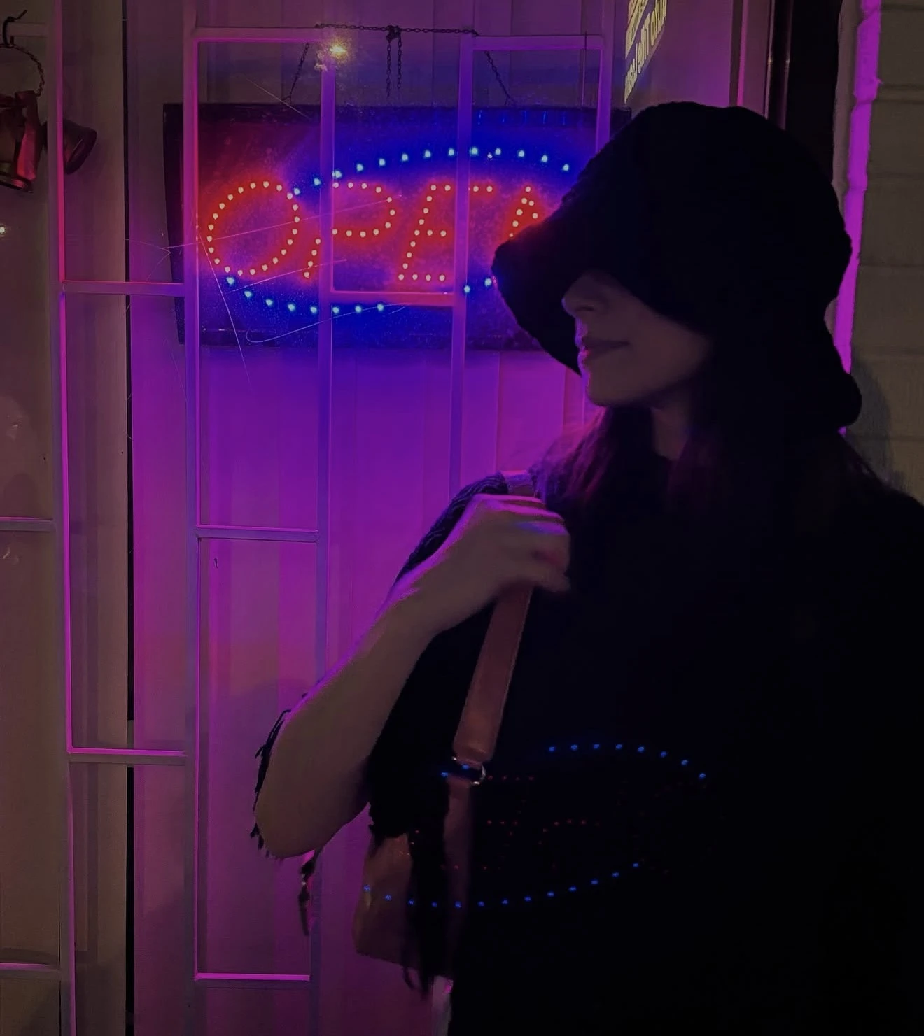 Ashlee at night under a neon open sign