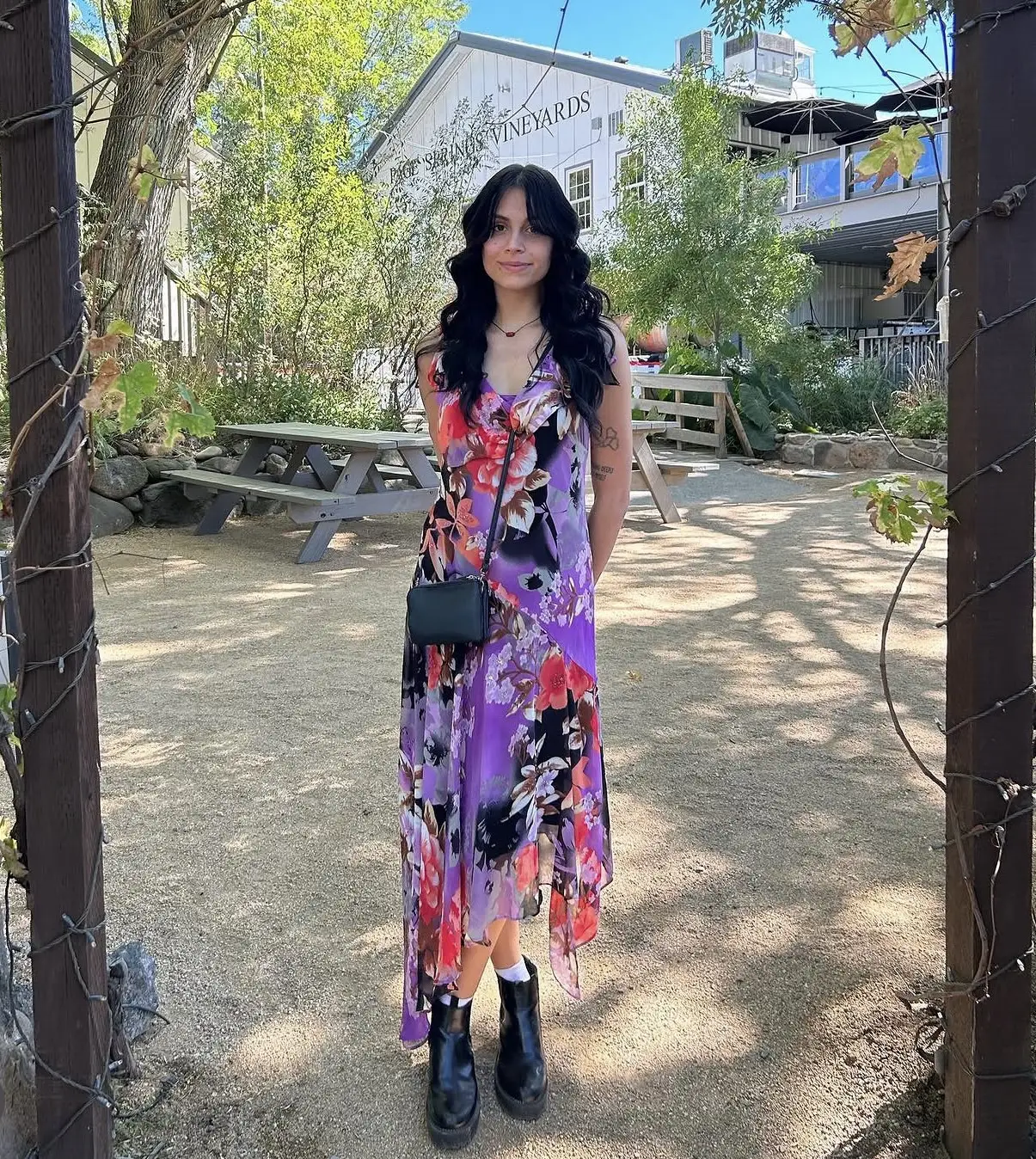 Ashlee smiling in a floral dress at a vineyard